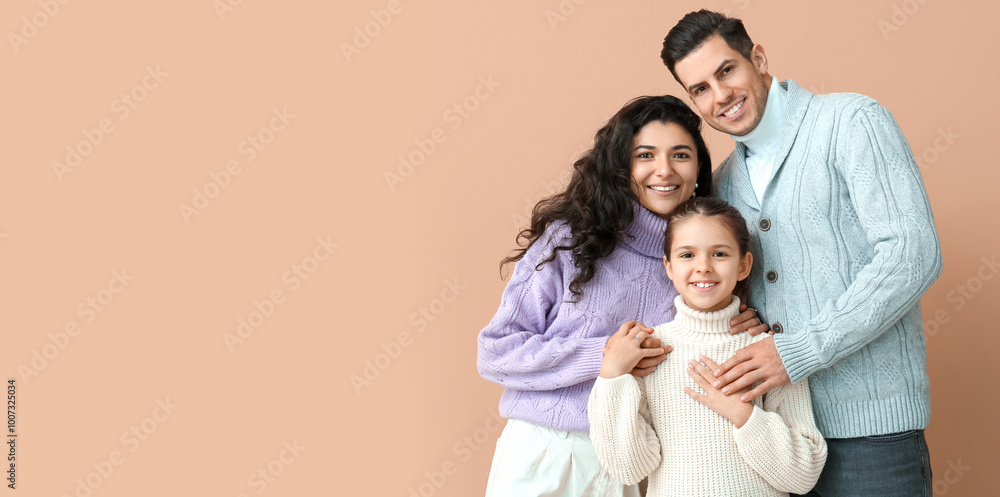 Little girl and her parents in warm sweaters on beige background Little girl and her parents in warm sweaters on beige background