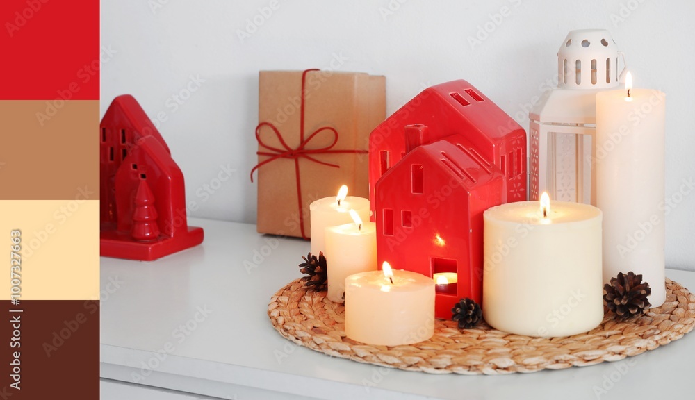 Burning candles with house shaped holders and Christmas gift on shelf in room. Different color patterns Burning candles with house shaped holders and Christmas gift on shelf in room. Different color patterns