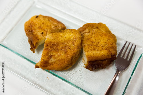 Crispy outside and smooth inside sweet Madrid torrijas served on glass plate. Spanish cuisine