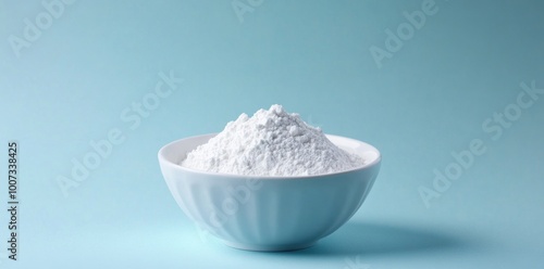 White powder in bowl on pastel blue background, space for text or product.
