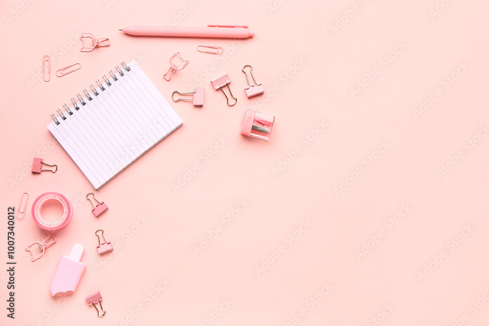 Notebook with different stationery supplies on pink background Notebook with different stationery supplies on pink background