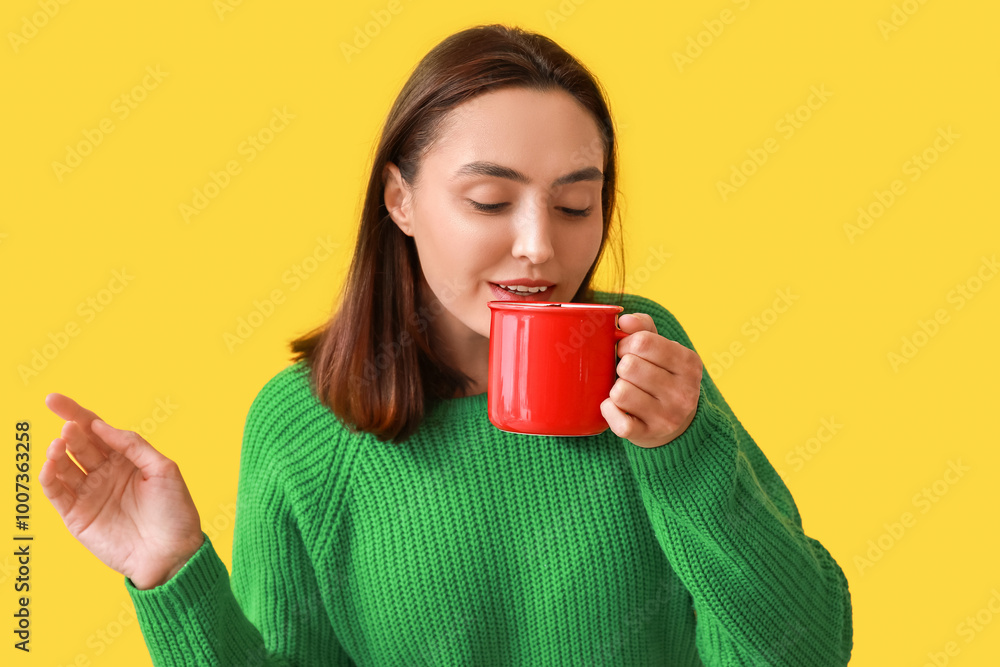 Beautiful young woman with cup of hot mulled wine on yellow background Beautiful young woman with cup of hot mulled wine on yellow background