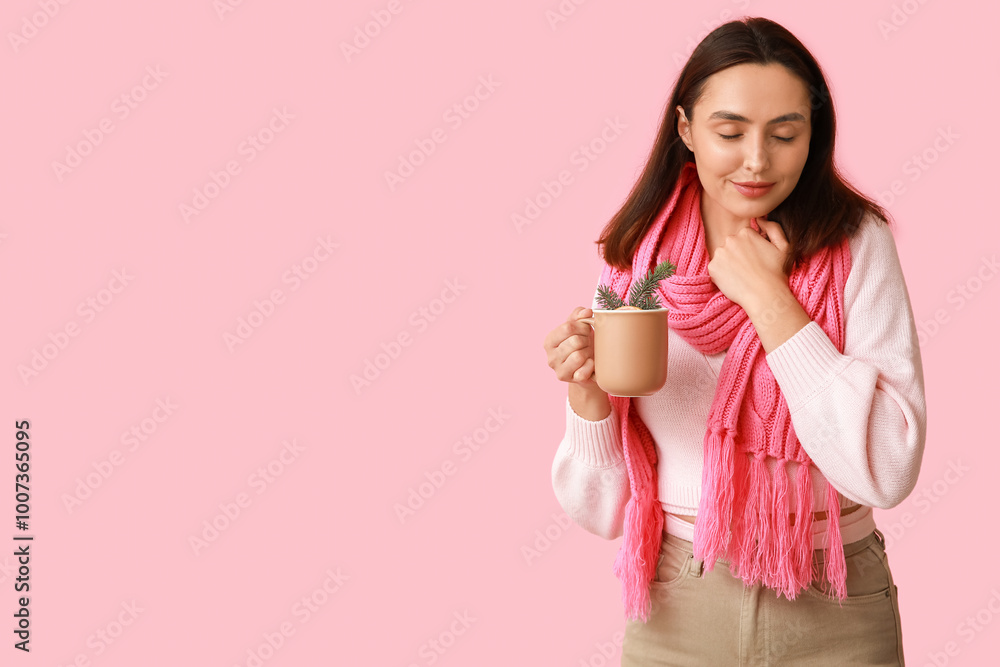 Beautiful young woman in scarf with cup of hot mulled wine on pink background Beautiful young woman in scarf with cup of hot mulled wine on pink background