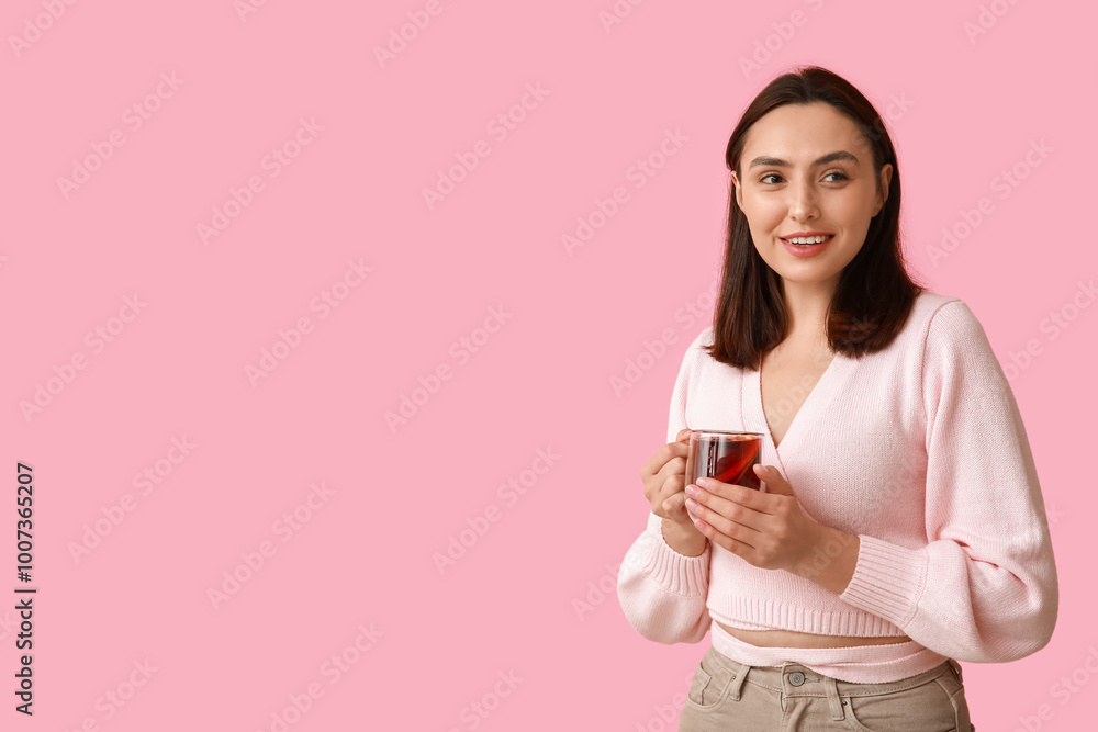 Beautiful young woman with glass cup of hot mulled wine on pink background Beautiful young woman with glass cup of hot mulled wine on pink background