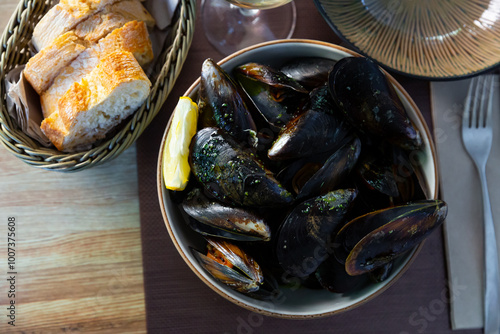 Picture of steamed tasty mussels with green sauce at plate, nobody.. photo