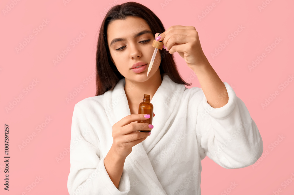 Beautiful young woman with bottle of cosmetic serum on pink background Beautiful young woman with bottle of cosmetic serum on pink background