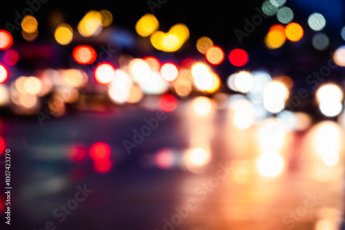 A blurry image of a city street at night with many cars and lights. Scene is busy and chaotic, with the bright lights and movement of the cars creating a sense of energy and excitement