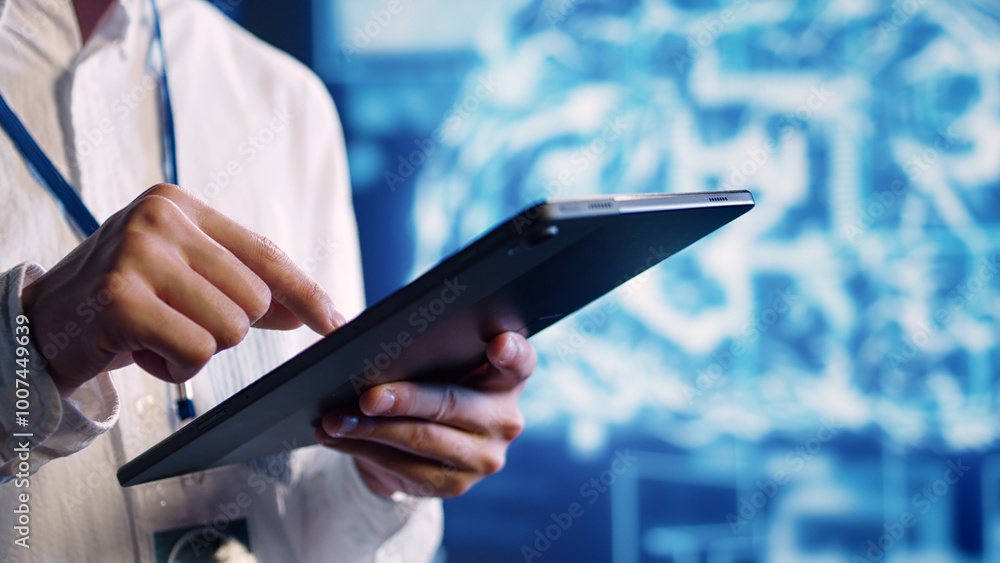 Close up shot of adept scientist in data center uses artificial intelligence computing simulating human brain thought processes. Skillful specialist works on tablet with AI machine learning algorithms Close up shot of adept scientist in data center uses artificial intelligence computing simulating human brain thought processes. Skillful specialist works on tablet with AI machine learning algorithms