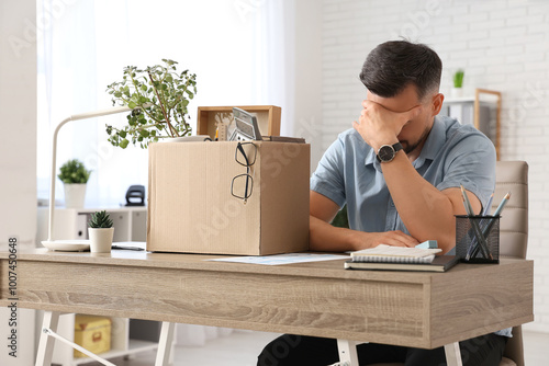 Sad fired man with box of p...