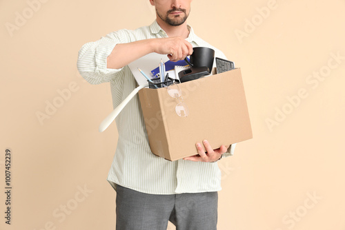 Fired young man packing his...