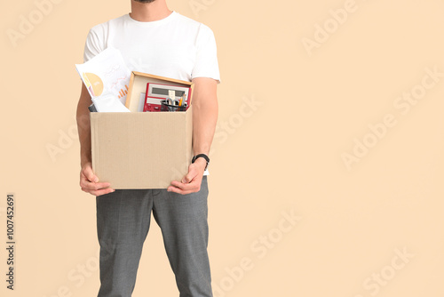 Fired young man holding box...