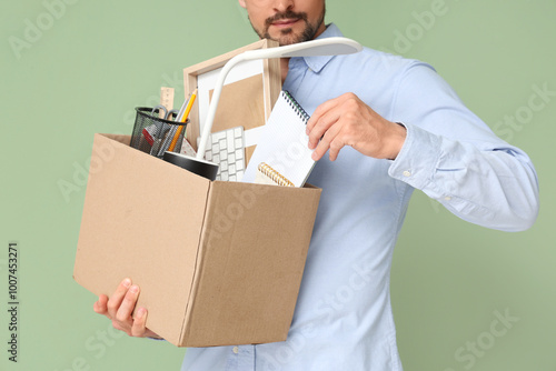 Fired young man packing his...