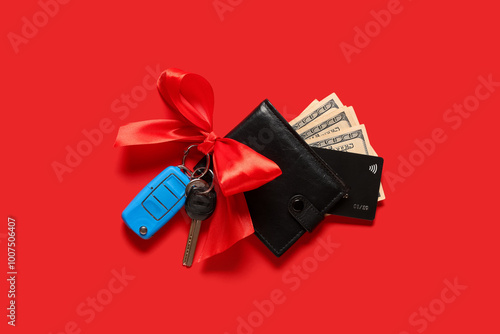 Gift keys of new car with bow, wallet, money and credit card on red background