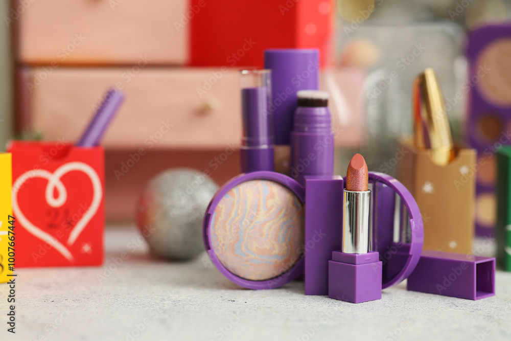 Naklejka premium Makeup products on table against blurred Christmas Advent calendar, closeup