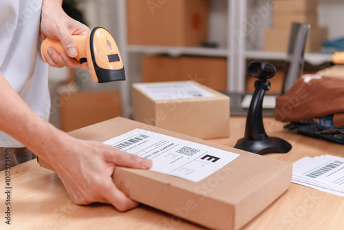 Photos Old person is applying a product label to a brown box with a barcode