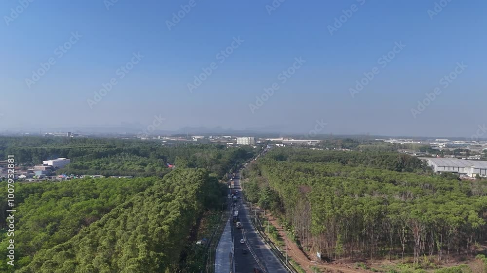 Aerial view of road with moving vehicles. Highway with views of green trees and industry. Aerial view of road with moving vehicles. Highway with views of green trees and industry.