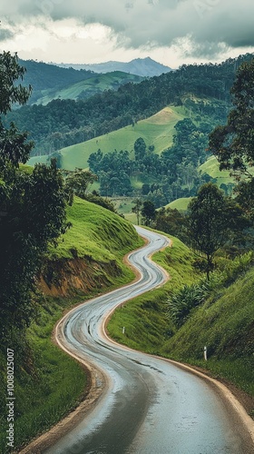 A winding road through lush green hills under a moody sky, perfect for capturing the essence of nature and adventure.