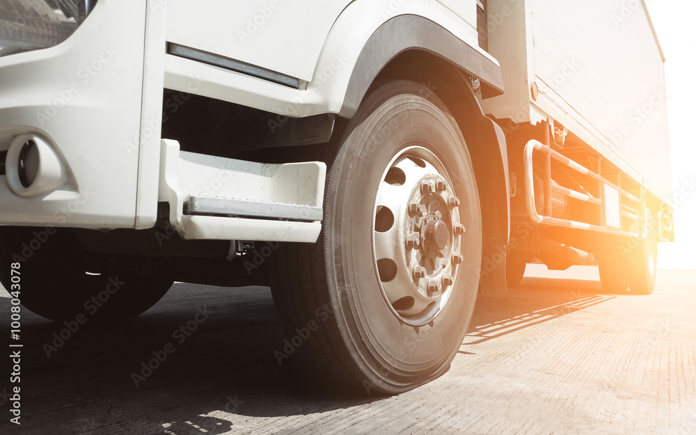 Trucks on The Parking Lot with The Sunshine. Truck Wheels Tires. Cargo Container Shipping. Lorry Diesel Truck. Freight Truck Logistics, Cargo Transportation. Trucks on The Parking Lot with The Sunshine. Truck Wheels Tires. Cargo Container Shipping. Lorry Diesel Truck. Freight Truck Logistics, Cargo Transportation.