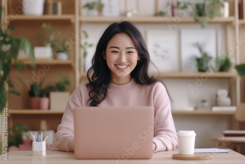 Woman in pink sweater working on laptop in home office