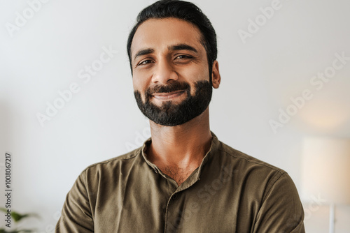 Confident, smiling indian male entrepreneur looking at camera standing on white background