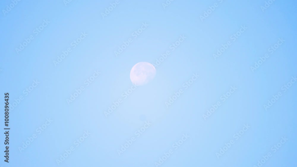 Moon is seen shining clearly against a bright blue sky in the middle of the day, creating a serene and tranquil scene Moon is seen shining clearly against a bright blue sky in the middle of the day, creating a serene and tranquil scene