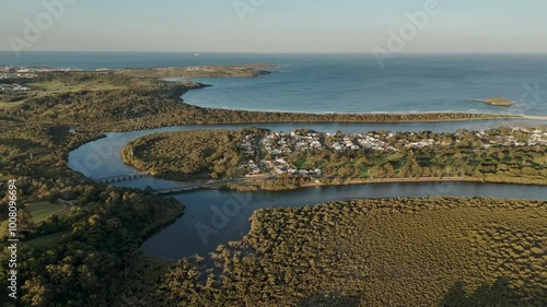 Aerial orbit over Minnamurra, Australia, with sweeping views of the coastline and green landscape, bridges connecting homes surrounded by water photo