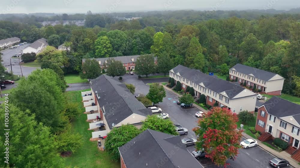 Aerial approaching shot of housing area with small garden in suburb. Dark foggy autumn day in America. Top down shot. Parking cars on parking area of community. Aerial approaching shot of housing area with small garden in suburb. Dark foggy autumn day in America. Top down shot. Parking cars on parking area of community.