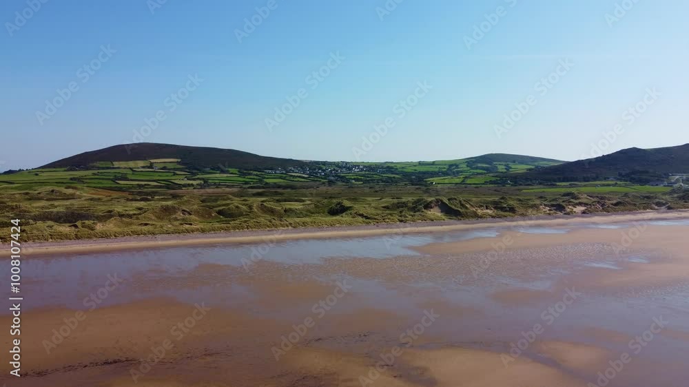 Aerial View of Sand Dunes on Rhossili Bay with Moorland Hills and Llangenith Rural Welsh Village in Background with Golden Sands on Hot Summer Sunny Day 4K Aerial View of Sand Dunes on Rhossili Bay with Moorland Hills and Llangenith Rural Welsh Village in Background with Golden Sands on Hot Summer Sunny Day 4K