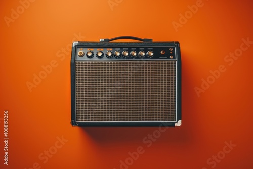 Vintage amplifier against a vibrant orange wall during a creative music session