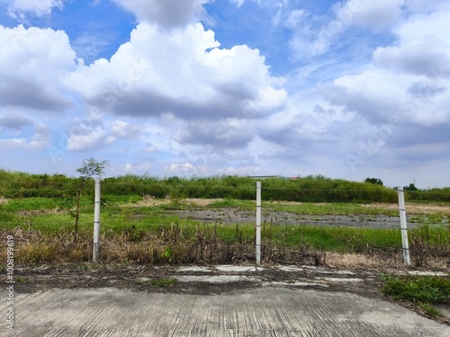 Land for sales concept. Landscape of empty land plot for development, and beautiful blue sky. 