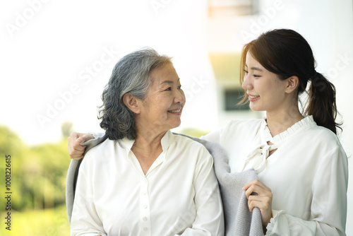 Daughter taking care of her mother by cover with blanket