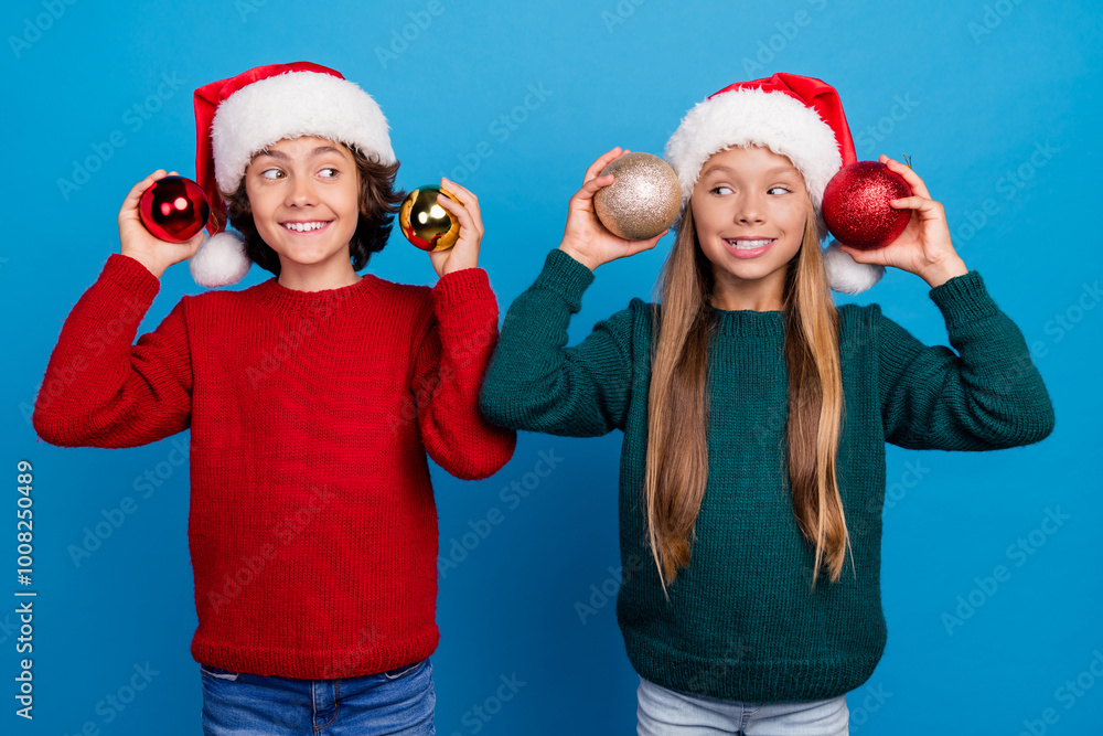 Photo of two kids excited hold christmas tree baubles decor isolated blue color background Photo of two kids excited hold christmas tree baubles decor isolated blue color background