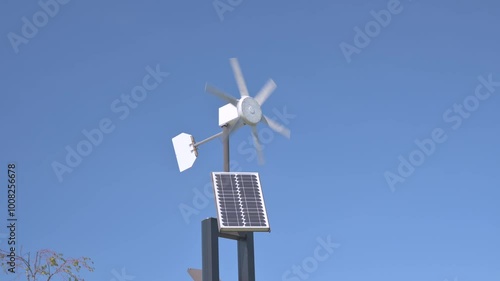 Small wind turbine wind propeller rotates by the wind against the blue sky.