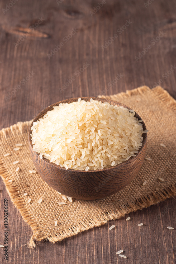 Uncooked white rice in a wooden bowl. Healthy cereal concept. Uncooked white rice in a wooden bowl. Healthy cereal concept.