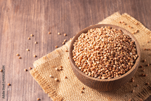 Buckwheat groats on wooden background. Healthy cereal concept