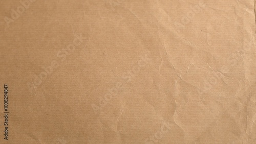 Light brown paper displays fine creases forming textured surface. Organic minimal aesthetic highlighted by subtle lighting offering depth to material simplicity