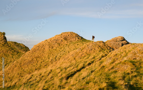 Photographer carrying a tripod and hiking on a mountain ridge. Te Mata Peak. Hawke’s Bay. photo