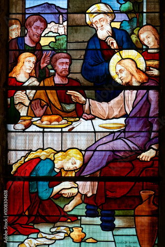 Stained glass (1926) of Saint Mary Magdalene washing the feet of Jesus Christ with perfume and her hair. .