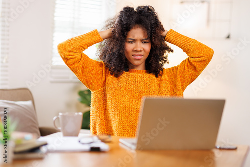 Portrait of sad upset woman feeling bad unwell with unhappy emotions holding hands on temples suffering from head ache sitting laptop desk. Health care concept 