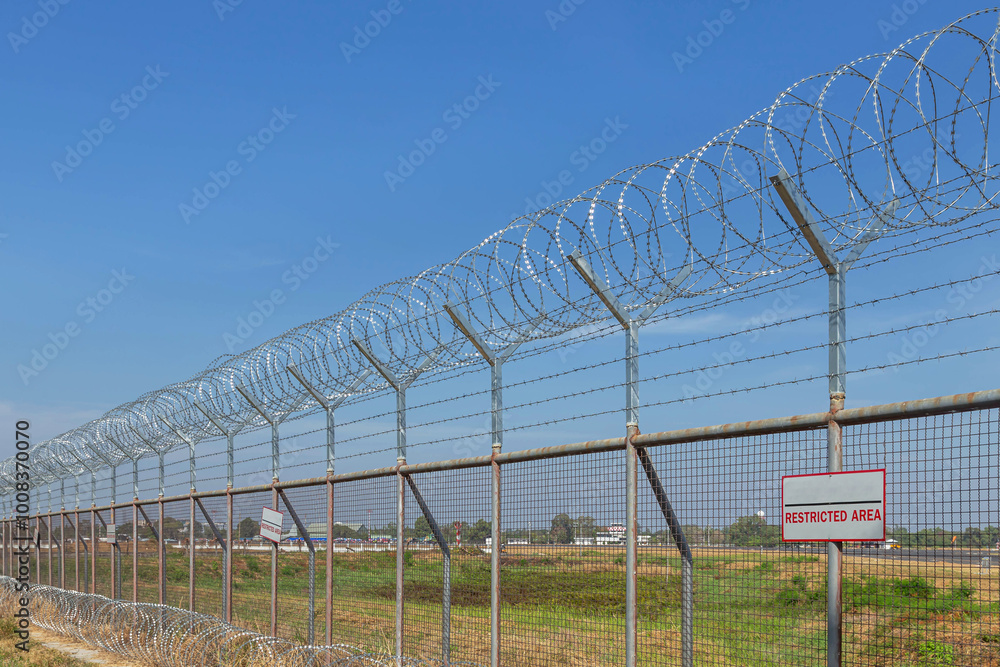 Razor barbed wire or concertina razor coil barrier security fence restricted area protection with blue sky Razor barbed wire or concertina razor coil barrier security fence restricted area protection with blue sky