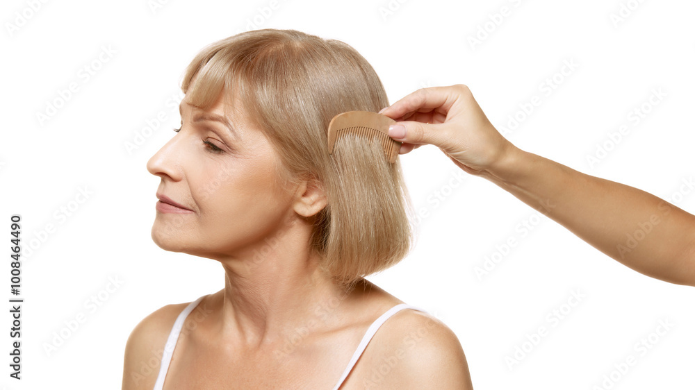 Careful hand combs through her silky hair, highlighting care and attention to detail against white studio background. Concept of beauty, wellness, cosmetology, anti-aging products. Ad Careful hand combs through her silky hair, highlighting care and attention to detail against white studio background. Concept of beauty, wellness, cosmetology, anti-aging products. Ad