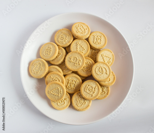 round cookies with various designs on them, including Christmas themed symbols like trees, snowmen, and other festive characters. vanilla or butter flavored sandwich cookies.