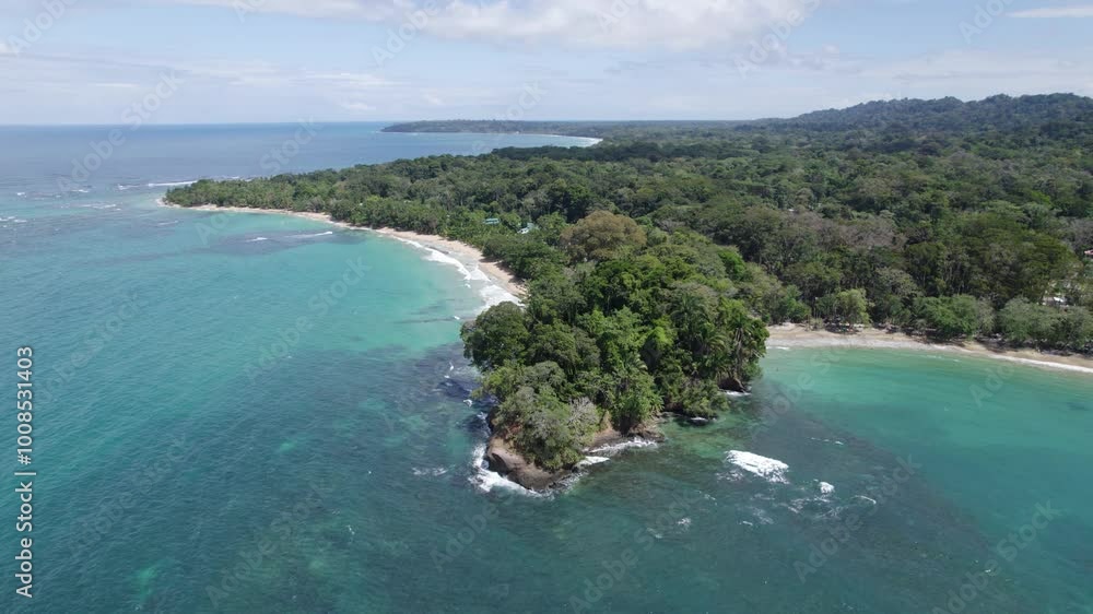 Aerial view of Punta Uva beach's pristine coastline surrounded by lush tropical trees and vibrant greenery in Costa Rica. Orbit Motion Shot Aerial view of Punta Uva beach's pristine coastline surrounded by lush tropical trees and vibrant greenery in Costa Rica. Orbit Motion Shot