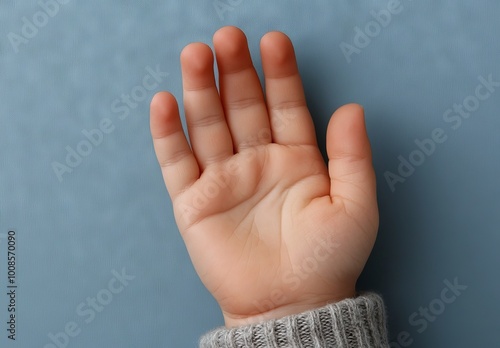 Close-Up of Child's Hand Listening to Teacher on Blue Background photo