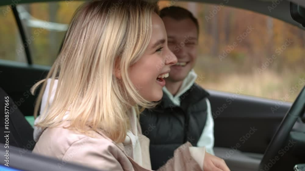 A woman and a man are engaged in a cheerful and lively conversation inside a parked car amidst beautiful nature A woman and a man are engaged in a cheerful and lively conversation inside a parked car amidst beautiful nature