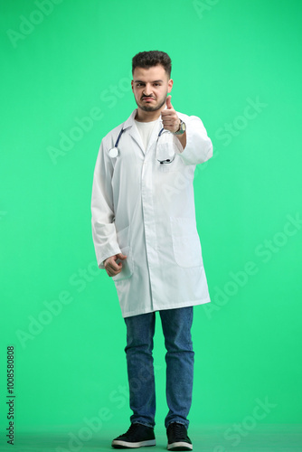 The doctor, in full height, on a green background, shows a thumbs up