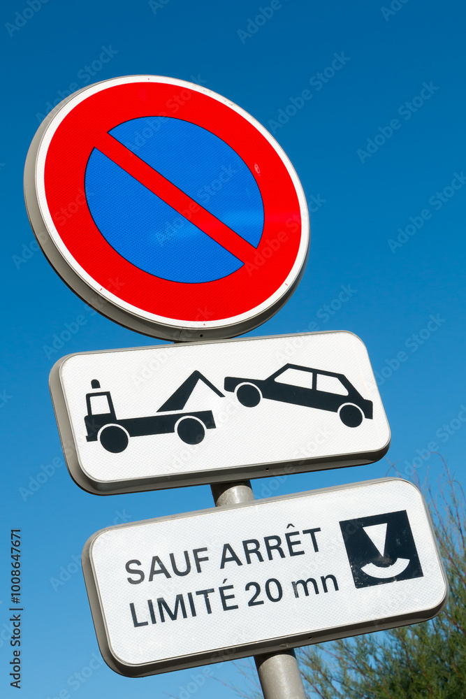 Road sign prohibiting parking in France with sign Except Stop limited to 20 mins