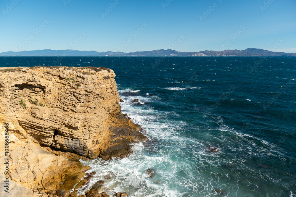 imagen de un acantilado en la costa del mediterráneo, des del pueblo de l'Escala, con el cielo azul y el mar con olas imagen de un acantilado en la costa del mediterráneo, des del pueblo de l'Escala, con el cielo azul y el mar con olas