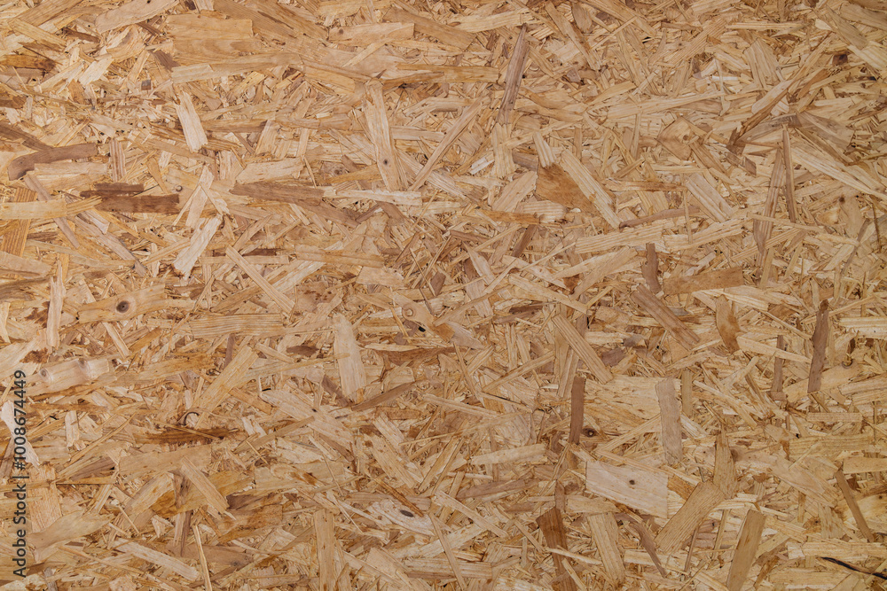 OSB board (Oriented Strand Board), showing overlapping wood fiber texture and light brown color OSB board (Oriented Strand Board), showing overlapping wood fiber texture and light brown color