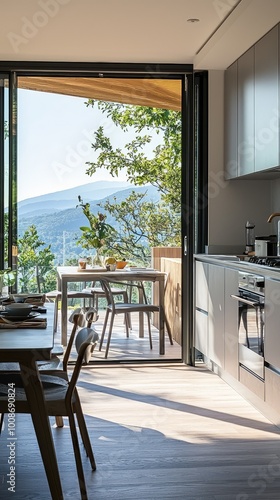Bright and modern kitchen with large windows, offering a stunning view of nature and outdoor dining area.
